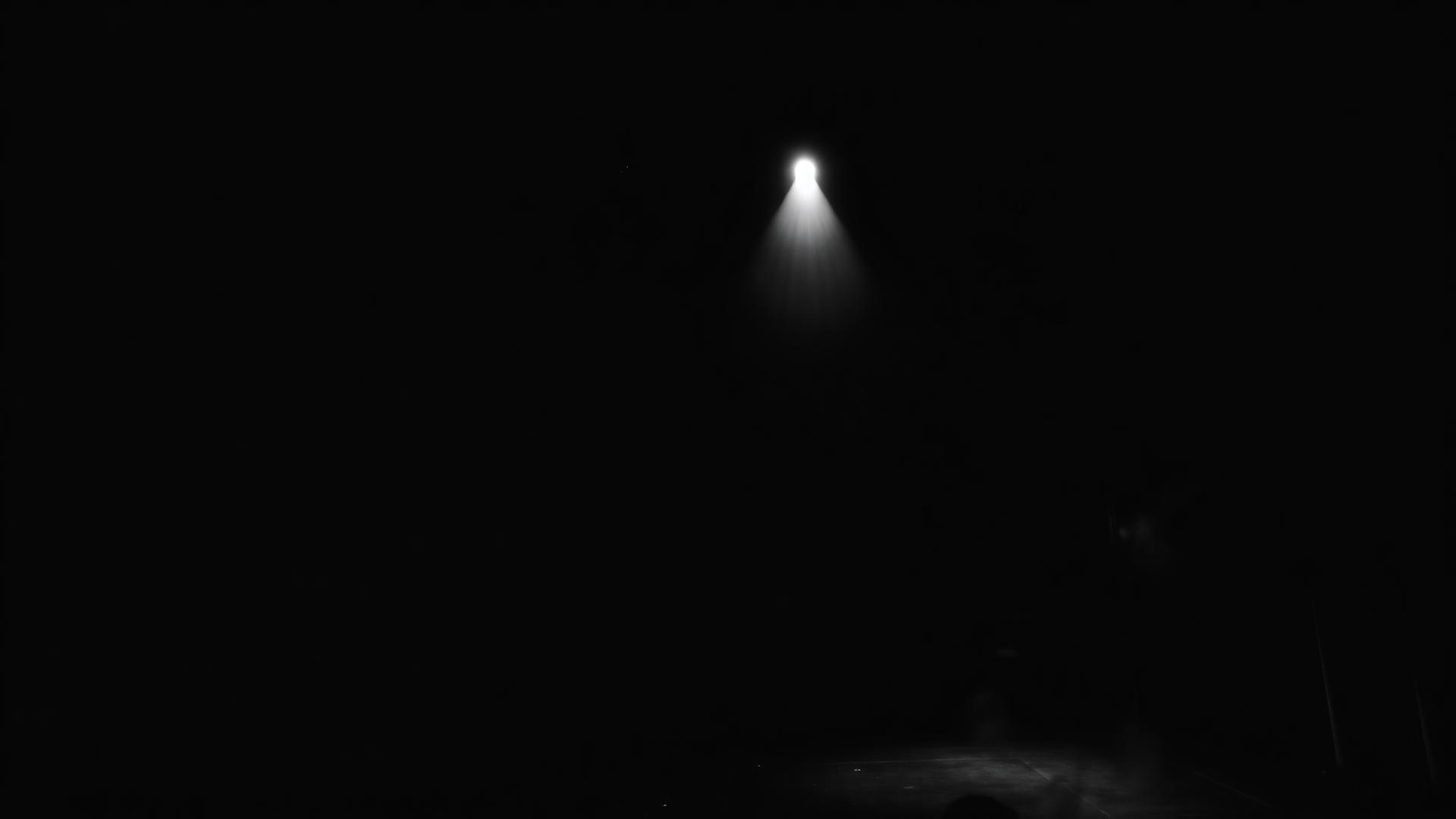 A single spotlight on a dark theatre stage